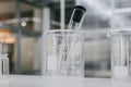 Beaker and test tubes in chemistry science laboratory background. Royalty Free Stock Photo