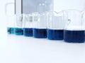 The beakers with color range  solution on bench laboratory, with stannous chloride solvent for analysis phosphate experiment. Royalty Free Stock Photo