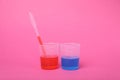 Beakers with colorful liquids on bright pink background. Kids chemical experiment set