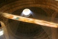 A beam of light passes through the interior dome of a chapel