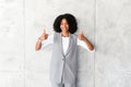 A beaming African-American businesswoman gives a double thumbs up
