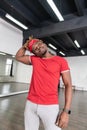 Beaming African American dancer with short dreadlocks standing on wooden floor