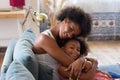 Beaming African American mother and daughter hugging