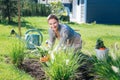 Beaming appealing woman enjoying her weekend while bedding plants