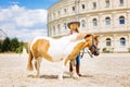 Beaming beautiful cowboy girl taking care of her pony Royalty Free Stock Photo