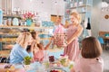 Beaming blonde-haired guest making presents attending baby shower