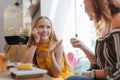 Beaming blonde-haired teenager enjoying talking to her mother