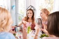 Beaming dark-haired woman posing for photo sitting in bakery