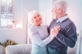 Beaming elderly lady feeling amazing while dancing with her husband