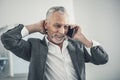 Beaming elderly man speaking by the phone