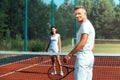 Beaming husband feeling amazing playing tennis with wife