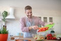 Beaming husband feeling excited while cooking dinner