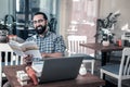 Beaming mature businessman feeling involved in reading Chinese book