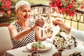 Beaming mature woman drinking wine with husband in the evening