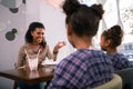 Caring beaming mother talking to her little lovely girls in cafeteria