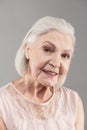 Beaming old woman with short hair working as model in studio Royalty Free Stock Photo