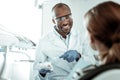 Beaming positive dentist wearing white uniform and protective glasses