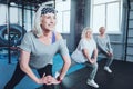 Beaming senior lady taking group training at gym Royalty Free Stock Photo