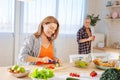 Beaming wife cutting vegetables for garden salad in the morning