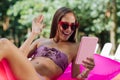 Beaming woman having video chat while swimming in the pool Royalty Free Stock Photo