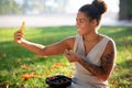 Beaming woman making selfie while eating berries