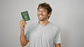 Beaming young man ecstatically waving his macao passport, soaking up happiness on stark white backdrop