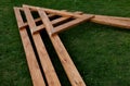 Beams connected by screws in the shape of v. future roof of the pergola fixed to the ground by means of metal foundation profiles Royalty Free Stock Photo