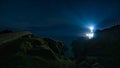 Beams of light shining from Fanad Head Lighthouse at dark night with sky full of stars