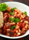 Bean and chorizo stew served in white bowl with parsley Royalty Free Stock Photo