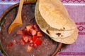 Beans cooked in a clay dish with tomato and tortillas, mexican poor dish Royalty Free Stock Photo