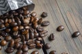 Beans poured out of the coffee bag. Lots of coffee beans. Coffee beans on the table next to the package. Fresh coffee Royalty Free Stock Photo