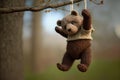 bear doll, hanging from a tree branch by its foot
