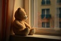 bear doll sitting on the window sill, watching the outside world Royalty Free Stock Photo