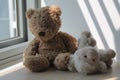 Bear and lamb toy sitting by the window in shadows Royalty Free Stock Photo