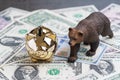 Bear market investing concept, golden piggy bank with bear figure walking on US Dollar banknotes Royalty Free Stock Photo