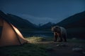 Bear near the tent. Camp on the lake. Beautiful night landscape with mountains Royalty Free Stock Photo