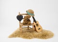 Bear plushie on a wooden chair and an acoustic guitar on a white background - vacation concept Royalty Free Stock Photo