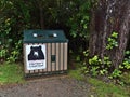 Bear proof garbage can at Wild Pacific Trail in Ucluelet, Vancouver Island in forest with big trees.