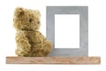 Bear sitting next to blank metal picture frame made of real silver, isolated on white