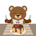 A bear is sitting at a table eating pancakes with chocolate and berries, isolated on a white background. Royalty Free Stock Photo