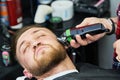 Beard care. man while trimming his facial hair cut at the barbershop Royalty Free Stock Photo