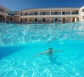 Beard man with glasses swimming under water in the pool on a tropical resort Royalty Free Stock Photo