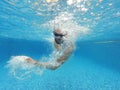 Beard man with glasses swimming under water in the pool Royalty Free Stock Photo