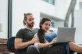 Beard man and his pregnant wife watching movie on laptop feeling happy while sitting on sofa in the home. Family concept Royalty Free Stock Photo