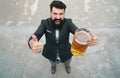 Beard man hold beer from a beer mug. Full length, wide angle. Expression emotions. Royalty Free Stock Photo