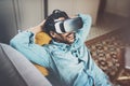 Bearded african man enjoying virtual reality glasses headset or 3d spectacles while relaxing on sofa at home.Blurred Royalty Free Stock Photo