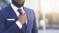 Bearded Afro Businessman Adjusting Tie In Urban Area, Cropped Royalty Free Stock Photo