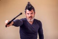 Bearded angry man with tonfa. People, emotions concept Royalty Free Stock Photo