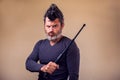 Bearded angry man with tonfa. People, emotions concept Royalty Free Stock Photo