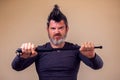 Bearded angry man with tonfa. People, emotions concept Royalty Free Stock Photo